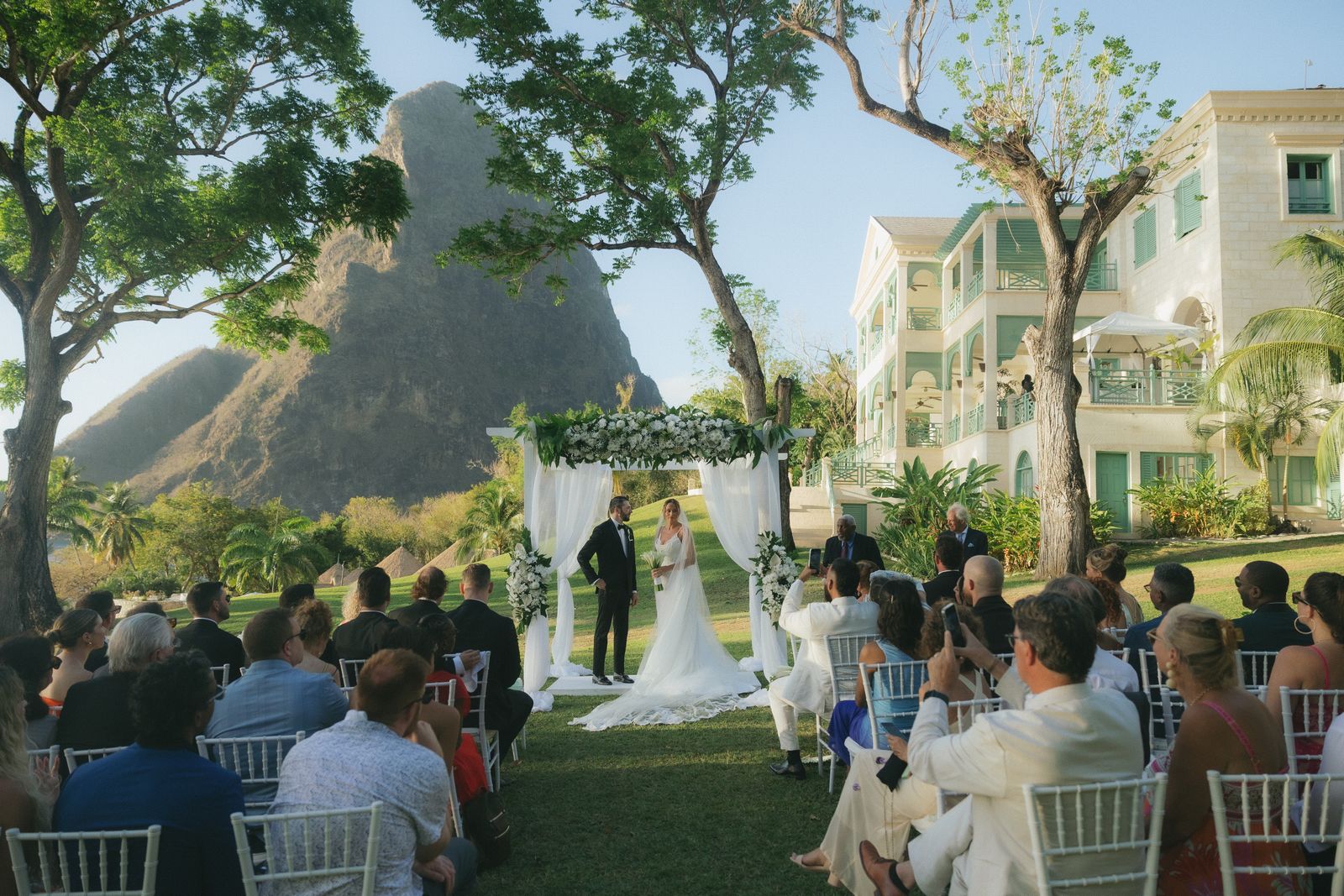 Image may contain Clothing Dress Fashion Formal Wear Gown Wedding Wedding Gown Plant Potted Plant Face and Head