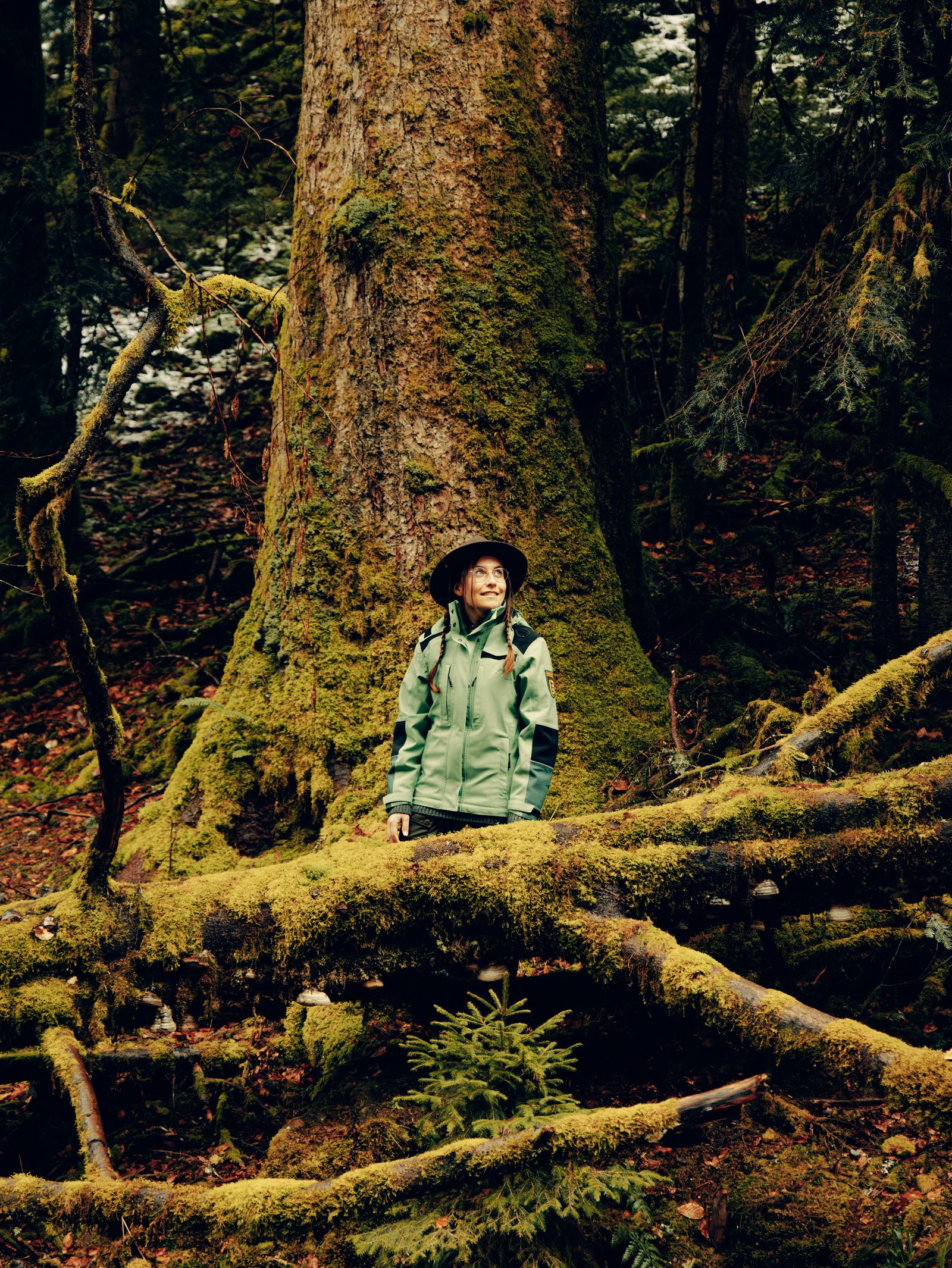 Image may contain Clothing Coat Plant Vegetation Land Nature Outdoors Rainforest Tree Grove Woodland and Moss