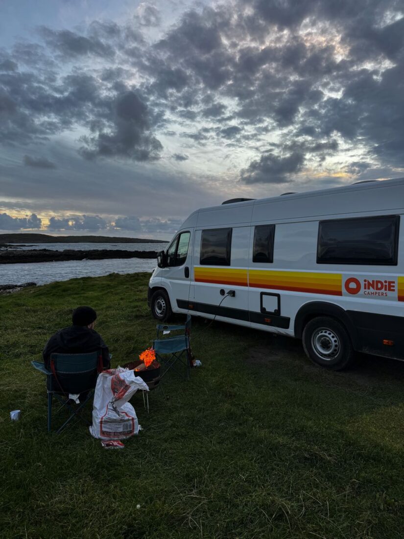van travel around ireland having a fire by the ocean