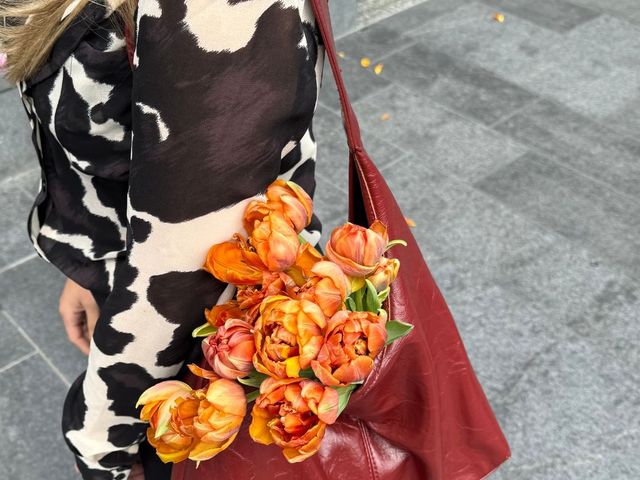 Red tote bag filled with orange flowers