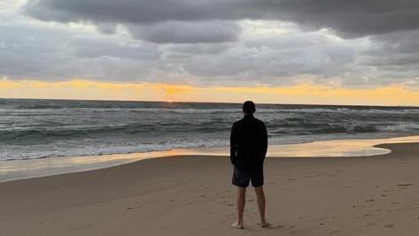 Damien Martyn stood on a beach at dawn, looking out to sea
