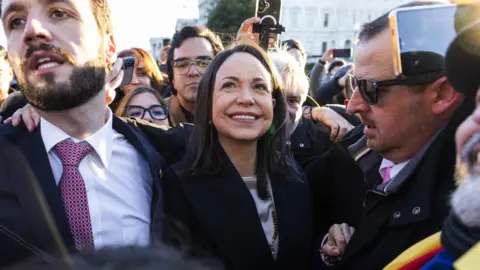 EPA/Shutterstock Maria Corina Machado smiles as she is guided by security through a crowd in Washington DC