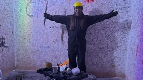 BBC Picture of a woman in a rage room wearing protective clothing