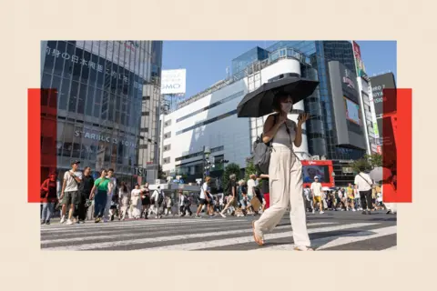 Getty Images A woman walks over a crossing in Tokyo