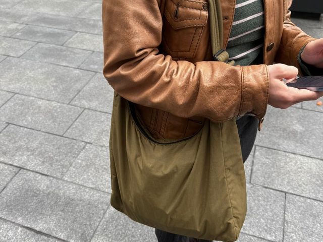 Editor carrying Baggu nylon tote in olive green