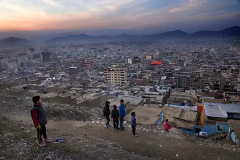 AP A boy flies a kite on a hilltop overlooking Kabul, Afghanistan, Feb. 27, 2022. (AP Photo/Hussein Malla, File)