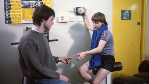 A publicity image of a young John Alford being offered drugs in the music video for Just Say No.