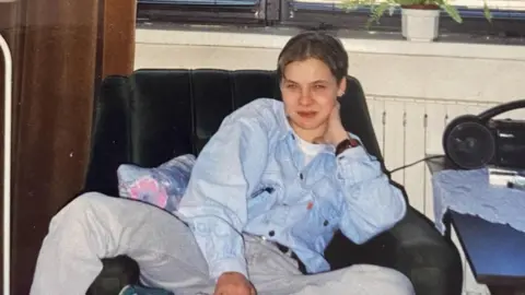 Supplied An old photograph of Izabela sat down wearing a blue denim jacket