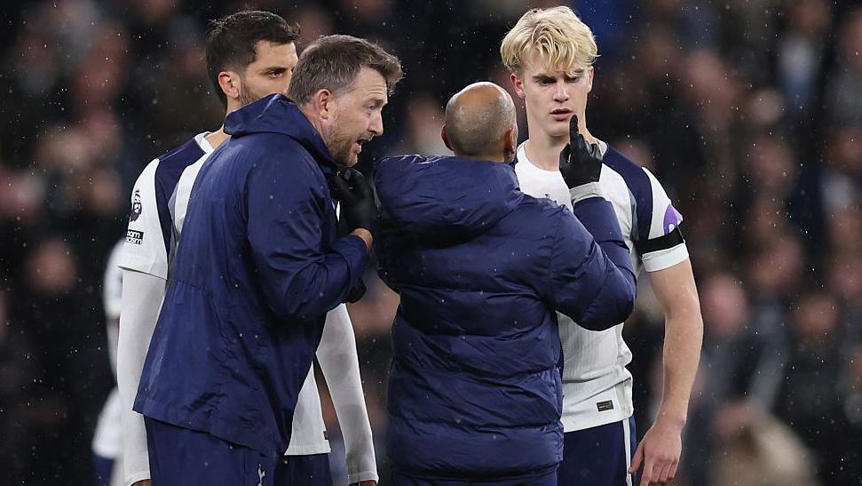 Lucas Bergvall of Tottenham Hotspur is treated by medical staff before he goes off with a concussion injury