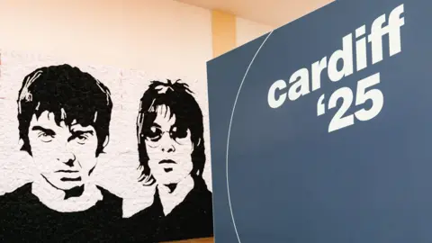 Getty Images A drawing of Noel and Liam Gallagher. A Cardiff '25 sign on the right indicates the start of the Oasis reunion tour.
