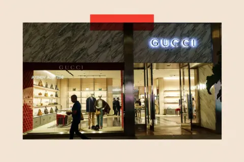 Getty Images A shopper walks past a Gucci store in a shopping mall in San Diego