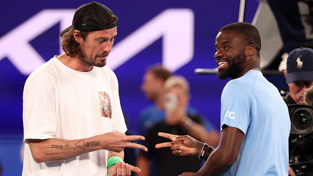 Frances Tiafoe and Marat Safin play rock, paper, scissors to decide who will serve