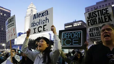 Getty Images People hold signs that read "Alexa, abolish ICE", "Deport ICE" and "Justice for Alex".