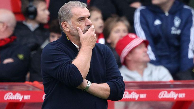 Ange Postecoglou looks glum while standing in the dugout as Nottingham Forest boss