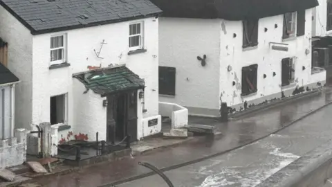 Peter Moore A general view of properties damaged by waves in Devon.
