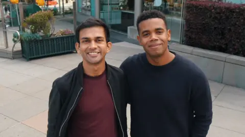 Anything Dhruv Amin and Marcus Lowe, the co-founders and co-CEOs of Anything smile and look up at the camera.