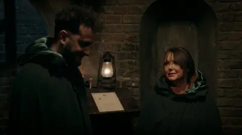 Wilfred and Amanda in the Traitors' cloaks in the turret