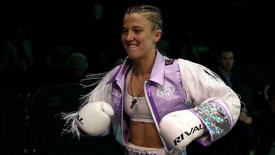 Francesca Hennessey smiling as she walks to the ring
