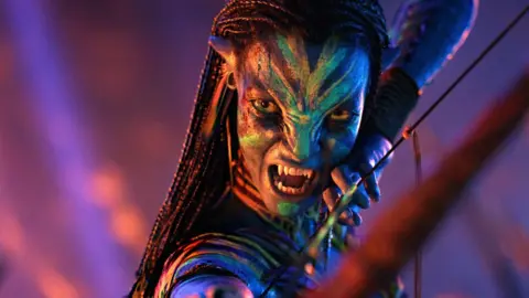 20th Century Studios Zoe Salda&ntilde;a as Neytiri te Tskaha Mo'at'ite in Avatar, pictured holding a bow and arrow