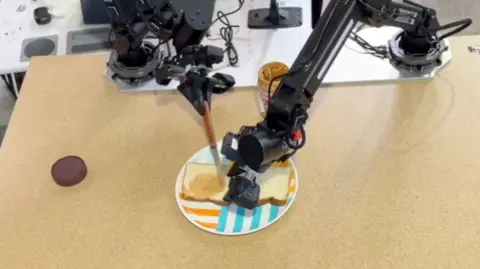 Physical Intelligence Robot hands making a peanut butter sandwich