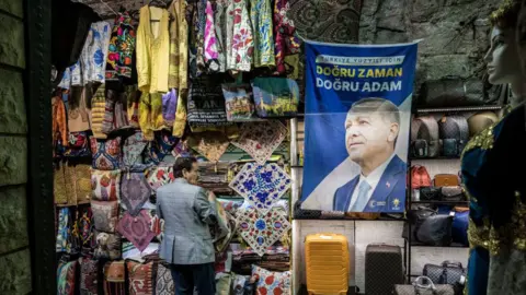 Getty Images A stall with colourful bags and pillow covers by a flag showing President Recep Tayyip Erdogan in a market in central Istanbul on May 29, 2023 in Istanbul, Turkey.