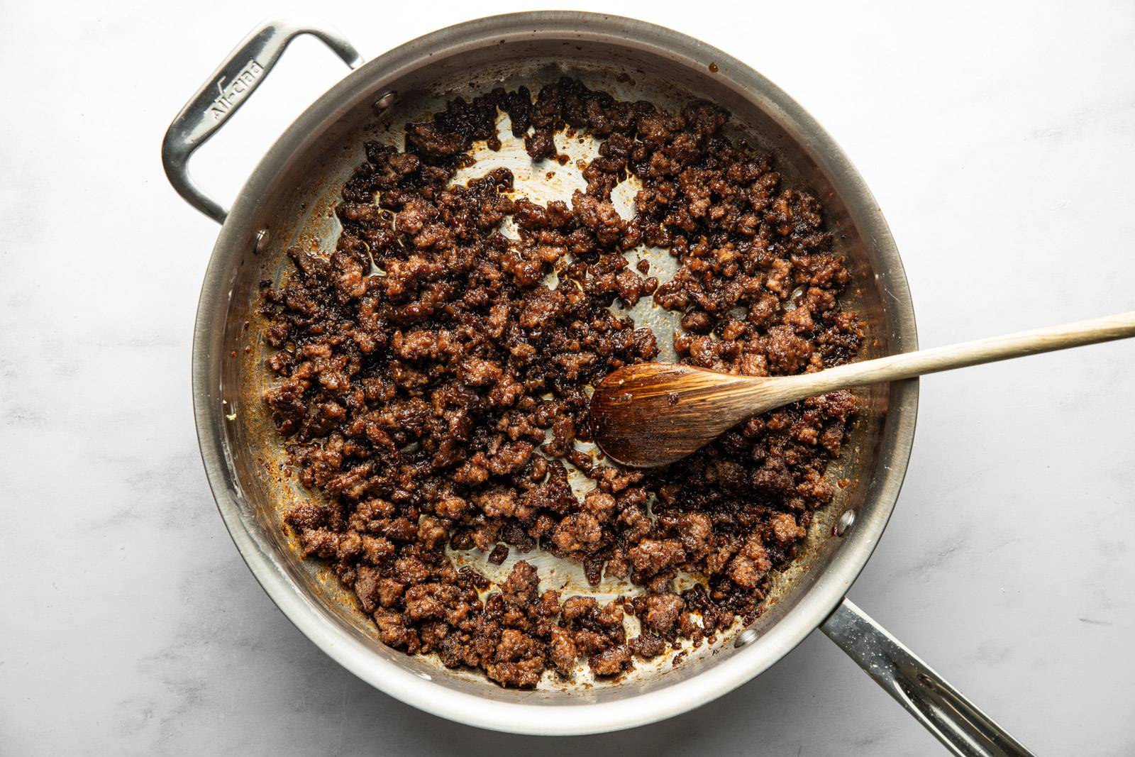 Sauce and garlic in pan with ground beef.