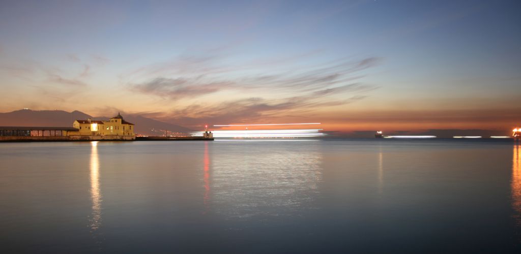 The view of the sea, the structure of the building, and the sunset sky.