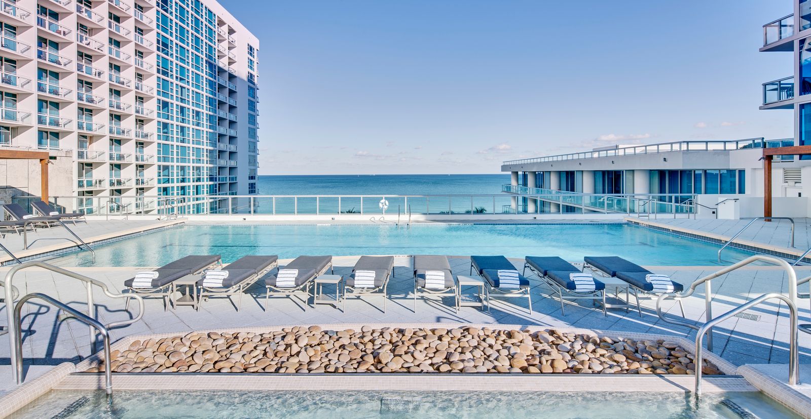 Image may contain Nature Outdoors Scenery Pool Water Swimming Pool Chair Furniture Sky Horizon and Person