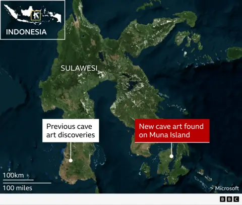 Oldest cave art discoveries in Sulawesi, Indonesia  A satellite-style map shows the Indonesian island of Sulawesi and surrounding sea, viewed from above with green land and dark blue ocean. Inset at the top left is a small map of Indonesia with a yellow box highlighting Sulawesi&rsquo;s location. Large white text labels the main island &ldquo;Sulawesi.&rdquo; Near the south‑west of Sulawesi, a white dot and white label read &ldquo;Previous cave art discoveries.&rdquo; To the south‑east, on a smaller adjoining landmass, a second white dot is connected to a bold red label that reads &ldquo;New cave art found on Muna Island.&rdquo; At the bottom left, a scale bar shows &ldquo;100 km&rdquo; above &ldquo;100 miles.&rdquo;
