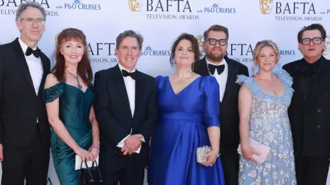 Getty Images The cast of Gavin and Stacey at the BAFTAs- Robert Wilfort, Melanie Walters, Rob Brydon, Ruth Jones, James Corden, Joanna Page and Mathew Horne  Brydon wears a black suit, whit shirt and black bow tie.