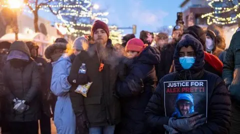 Getty Images People mourn at a memorial in the area where 37-year-old Alex Pretti was shot dead by federal immigration agents earlier in the day in Minneapolis, Minnesota, on January 24, 2026.