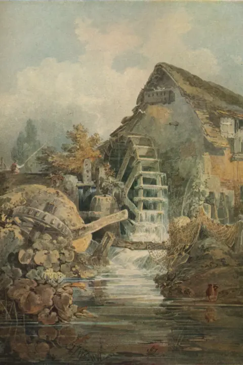 Getty Images Marford Mill, Denbighshire, a water-colour by J. M. W. Turner. An old-fashioned watermill sits beside a calm stream in a rustic countryside setting. The mill has a large wooden waterwheel with cascading water flowing down its paddles, creating a gentle motion. The building is weathered, with a sloping roof covered in moss or thatch, and small windows with white shutters. Fishing nets are draped over rocks near the water&rsquo;s edge, and clay jugs rest on the ground by the stream. In the foreground, the water reflects the surrounding greenery and stones, while lush plants and flowers grow along the banks. In the background, tall trees rise against a soft, cloudy sky, adding to the tranquil, pastoral atmosphere.