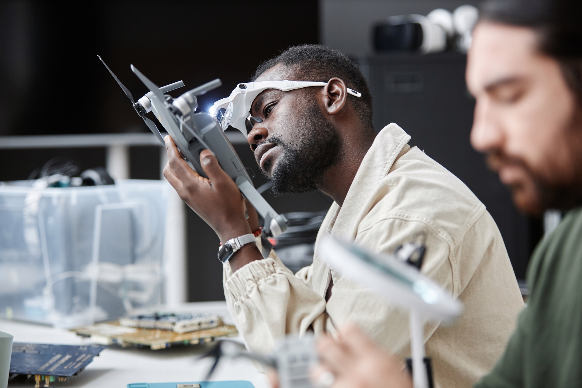Black Man Disassembling Drone in Repair Shop