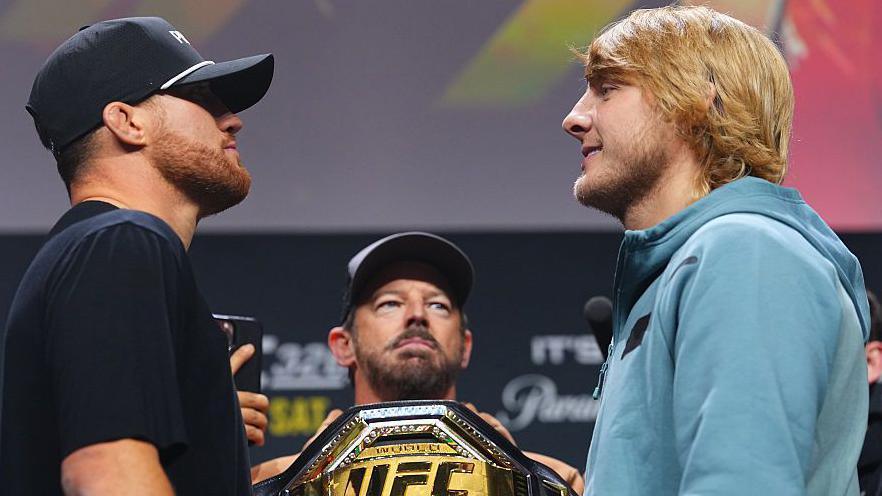 Justin Gaethje and Paddy Pimblett face off with the UFC belt in between them