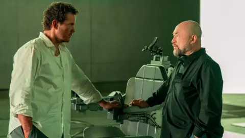 2025 Amazon Content Services LLC Chris Pratt and director Timur Bekmambetov on set, next to the chair Pratt was locked into during filming