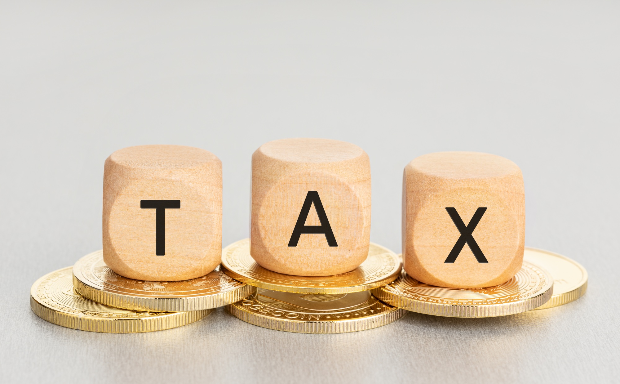 Cryptocurrency TAX concept. Coins and wooden blocks with text. Copy space