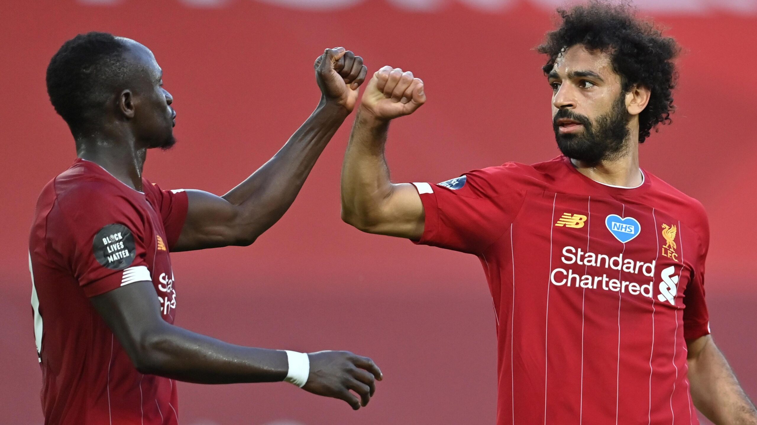 Sadio Mane and Mohamed Salah bump fists while celebrating a goal for Liverpool
