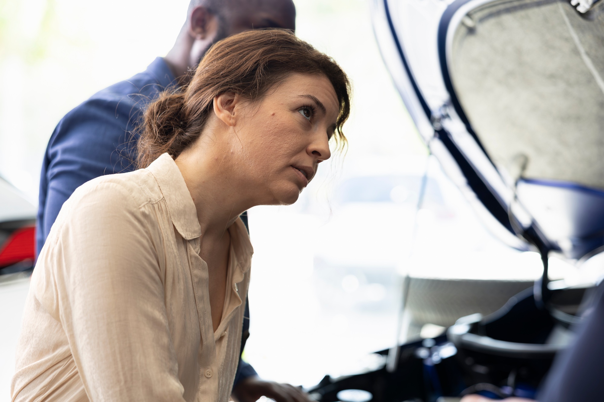 Dealership salesman showing clients parts used inside car