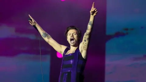 Getty Images Harry Styles raises his hands to the air during a performance at Radio 1's Big Weekend in 2022
