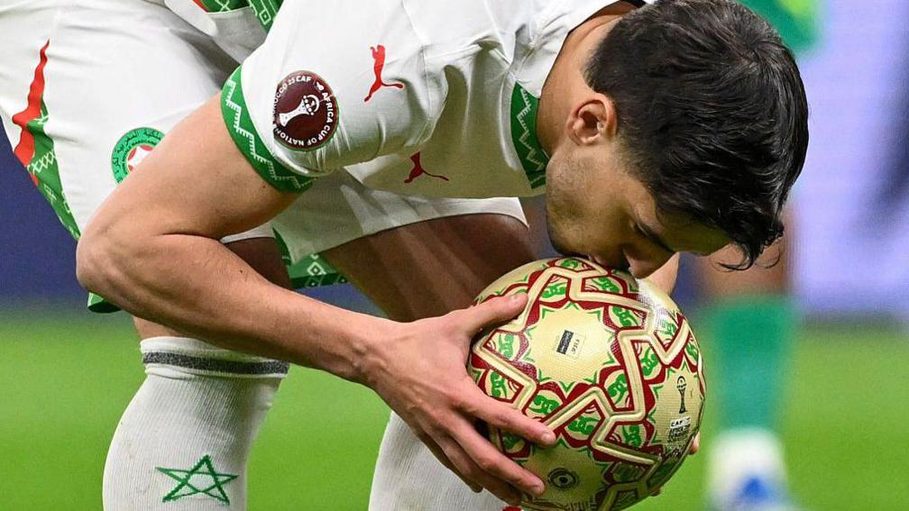 Brahim Diaz kisses the football moments before taking a penalty