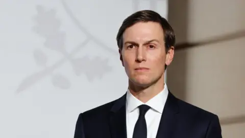 EPA An image of Jared Kushner dressed in a black suit with a white shirt staring off into the distance.
