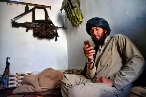 AFP via Getty Images A Taliban security personnel uses a non-smartphone in Kandahar on June 17, 2025, The Talibans' Supreme leader Hibatullah Akhundzada had called officials and scholars on reducing their use of smartphones.