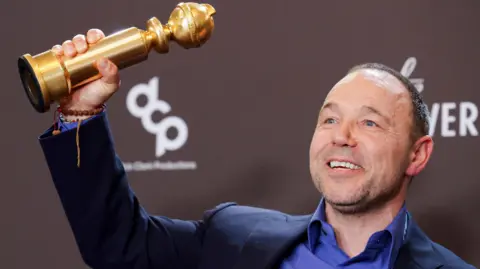 Reuters Stephen Graham holding up a Golden Globe