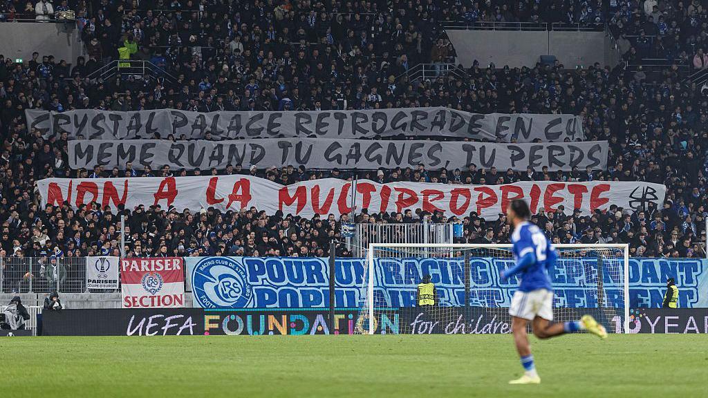 Strasbourg fans display a message of support to Crystal Palace against multi-club ownership