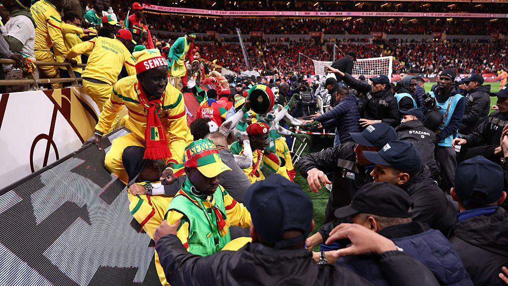 Security personnel block angry fans over a penalty decision against Senegal during the Africa Cup of Nations final