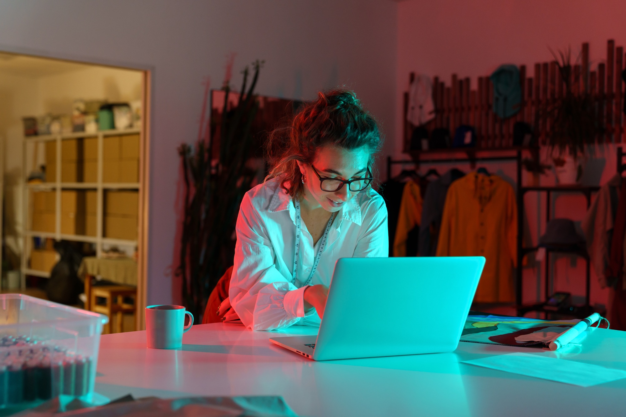 Professional female tailor order textile for clothes collection online on laptop computer in atelier