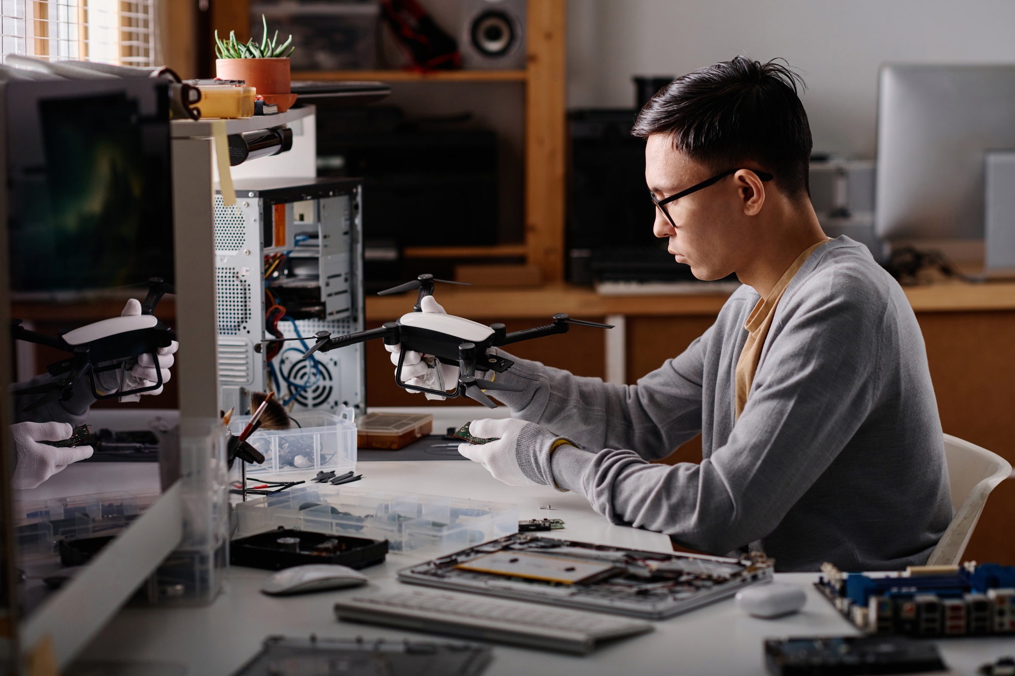 Professional Technician Checking Drone Before Repairing in Workshop
