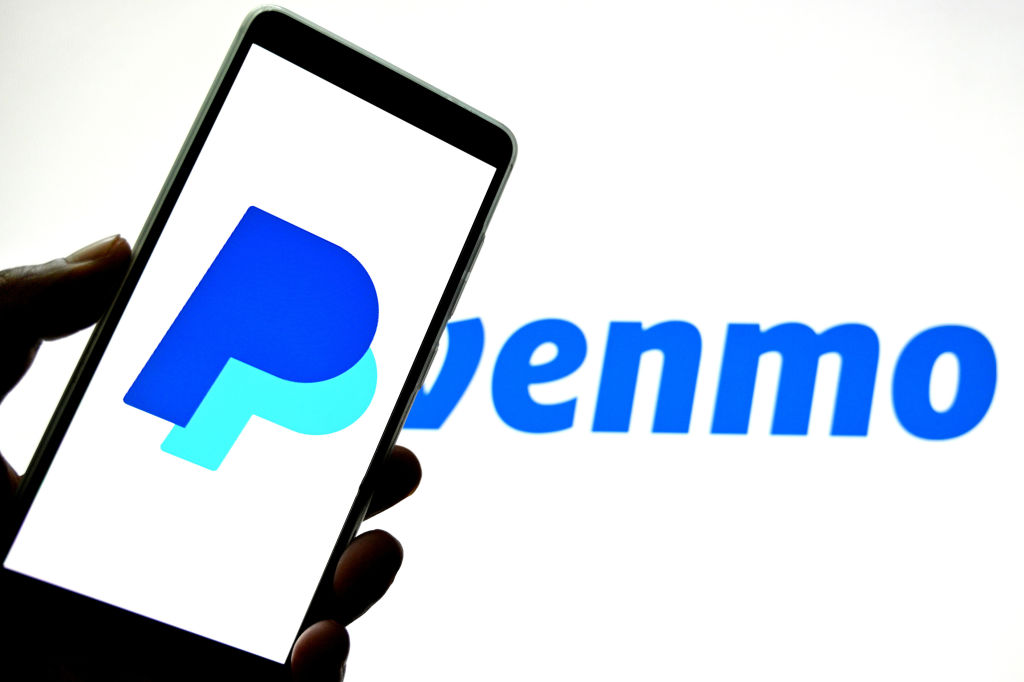 Paypal logo is seen displayed on a smartphone with a Venmo logo