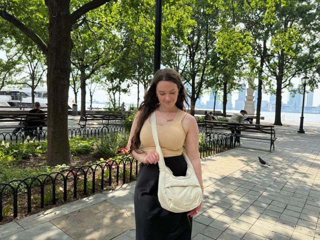 Image may contain: Accessories, Bag, Handbag, Adult, Person, Jewelry, Necklace, Bench, Furniture, Animal, Bird, and Sitting