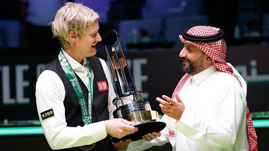 Neil Robertson being presented with the Saudi Arabia Snooker Masters trophy